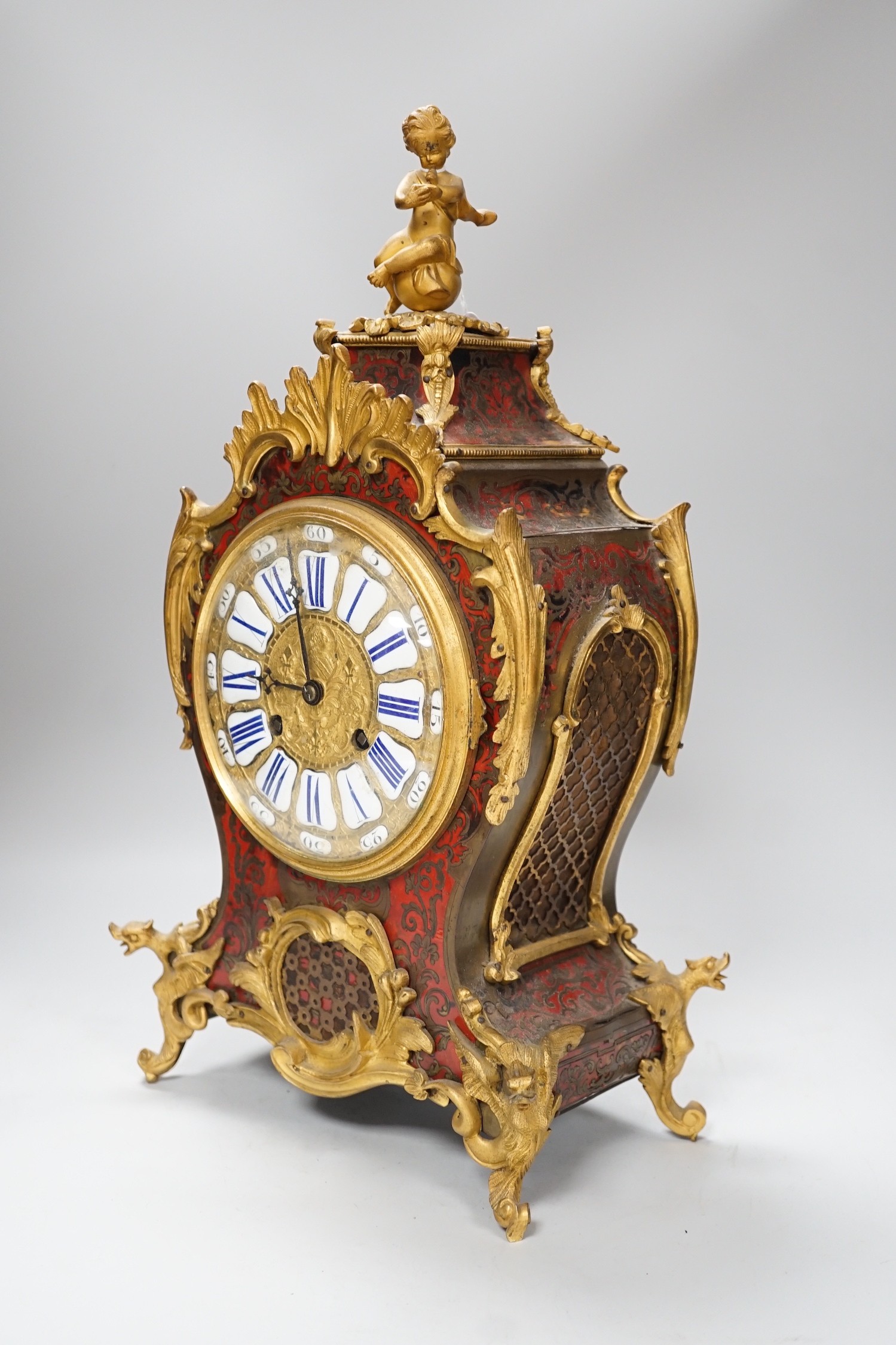 A French scarlet Boulle work and ormolu mounted mantel clock with enamel dial, 45cms high
